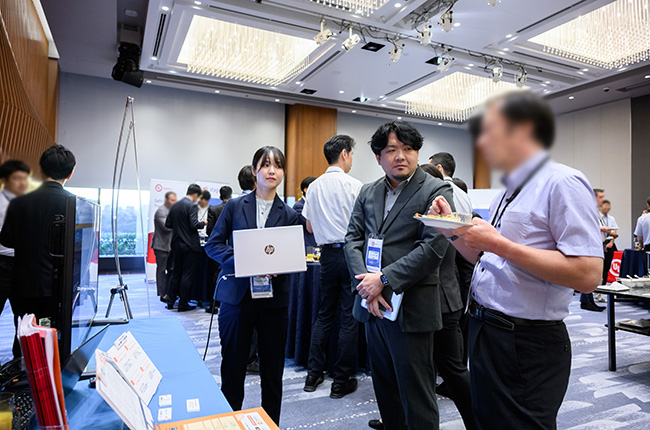 弊社展示ブースで来場者の声に耳を傾ける場面