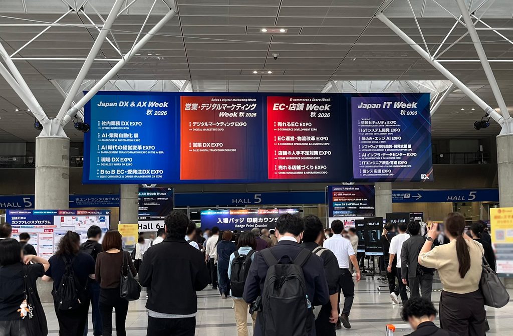 「Japan DX & AX Week 秋 2026」の案内板と、会場を行き交う来場者